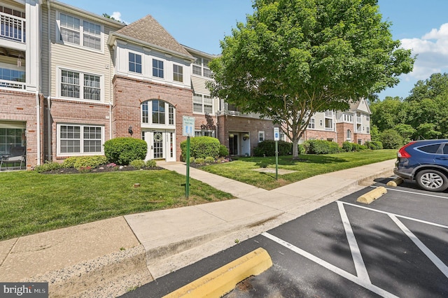 1402 Bonnett Pl Unit 131, Bel Air, MD 21015 - view of front of house with uncovered parking, brick siding, a front lawn, and a residential view