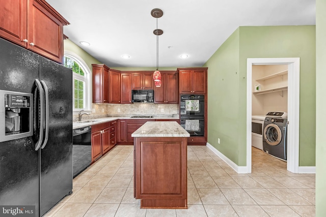 26635 Del Ibera Ct, Mechanicsville, MD 20659 - kitchen featuring black appliances, washer / dryer, a sink, a kitchen island, and backsplash