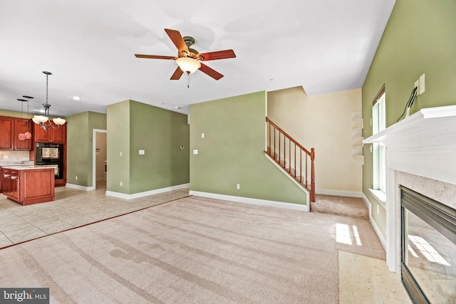 26635 Del Ibera Ct, Mechanicsville, MD 20659 - unfurnished living room with a ceiling fan, stairs, a high end fireplace, baseboards, and light colored carpet