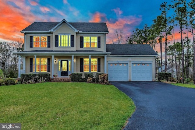 26635 Del Ibera Ct, Mechanicsville, MD 20659 - view of front of house with a garage, driveway, a yard, covered porch, and roof with shingles
