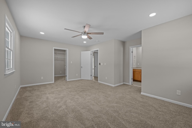 21830 Vaughn Rd, Georgetown, DE 19947 - unfurnished bedroom with light carpet, a spacious closet, baseboards, recessed lighting, and connected bathroom