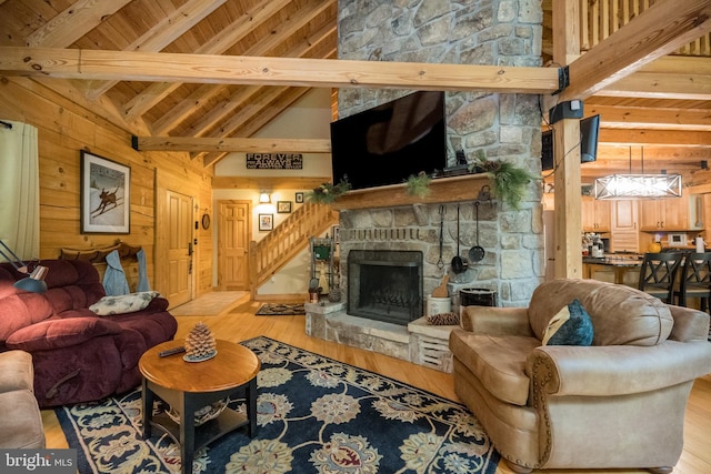 532 Pine Grove Rd, Lonaconing, MD 21539 - living area with beamed ceiling, light wood-style floors, a stone fireplace, stairway, and wooden walls