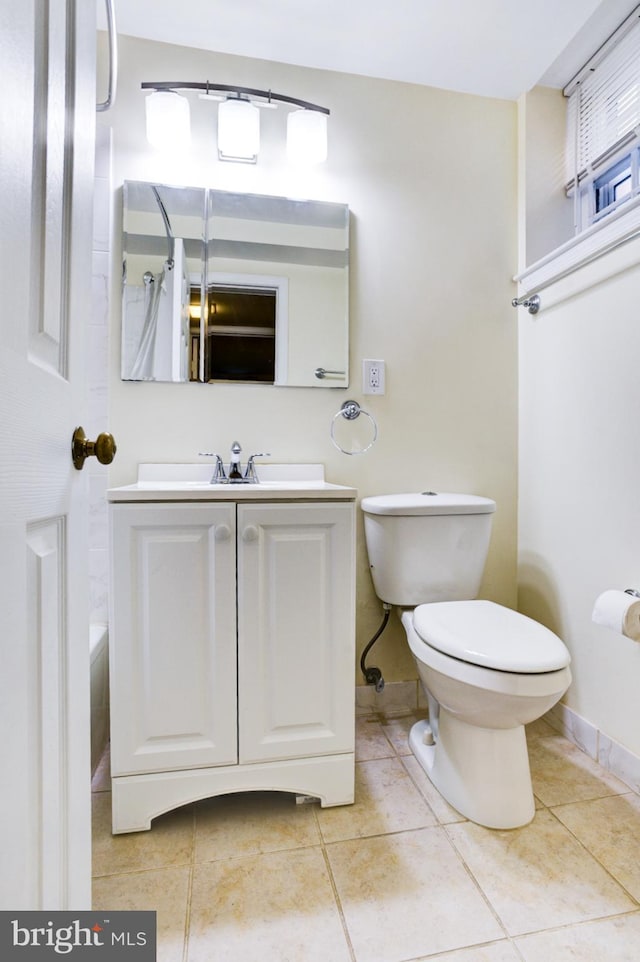 bathroom with baseboards, toilet, tile patterned floors, and vanity