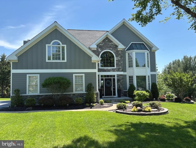 view of front of home with stone siding, board and batten siding, and a front yard