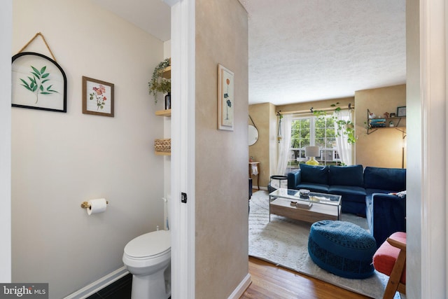 104 Braeburn Dr, Winchester, VA 22601 - bathroom with baseboards, wood finished floors, a textured ceiling, and toilet