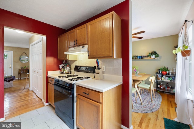 104 Braeburn Dr, Winchester, VA 22601 - kitchen with gas stove, under cabinet range hood, light countertops, decorative backsplash, and a ceiling fan