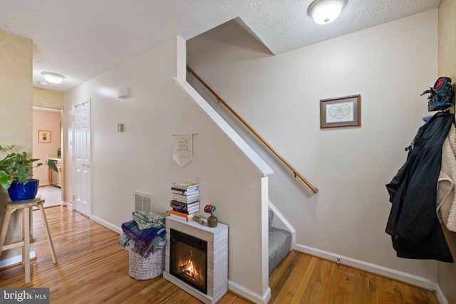 104 Braeburn Dr, Winchester, VA 22601 - stairway featuring wood finished floors, baseboards, a textured ceiling, and a glass covered fireplace