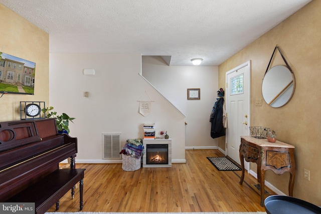 104 Braeburn Dr, Winchester, VA 22601 - entrance foyer featuring wood finished floors, a glass covered fireplace, baseboards, and a textured ceiling
