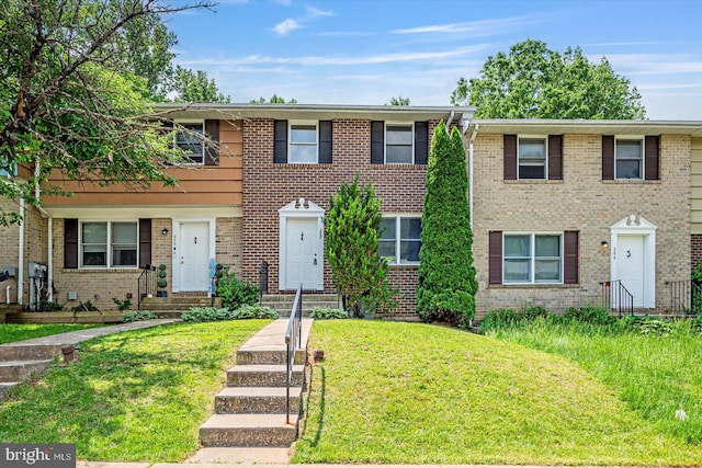 townhome / multi-family property featuring brick siding and a front lawn