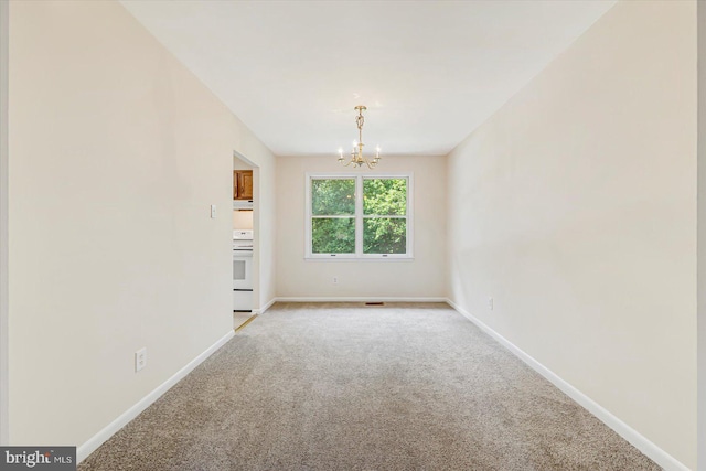 unfurnished living room with a chandelier, light carpet, and baseboards