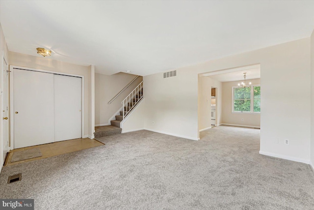 entrance foyer with a chandelier, stairs, carpet flooring, and baseboards