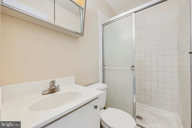 bathroom featuring toilet, a tile shower, and vanity