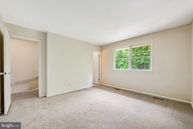 empty room featuring carpet floors and baseboards