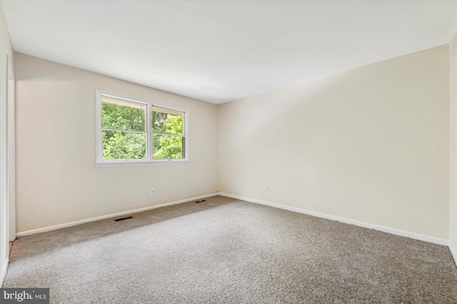 unfurnished room with carpet and baseboards