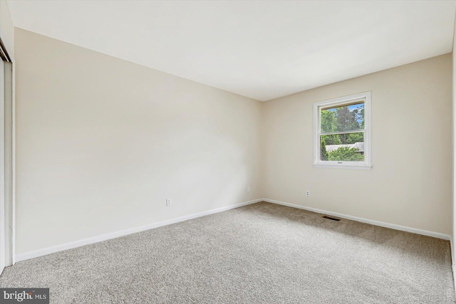 spare room featuring carpet and baseboards