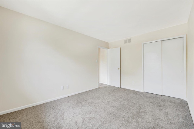 unfurnished bedroom with carpet floors, baseboards, and a closet