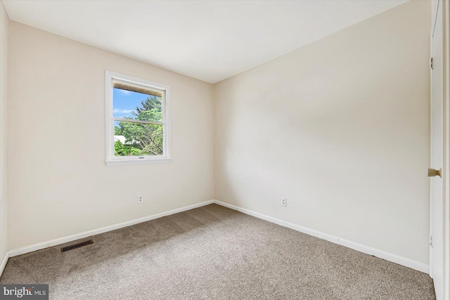 carpeted empty room featuring baseboards