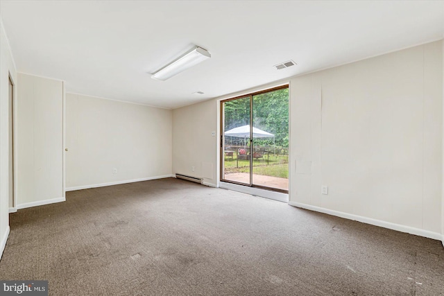 carpeted spare room featuring a baseboard heating unit and baseboards