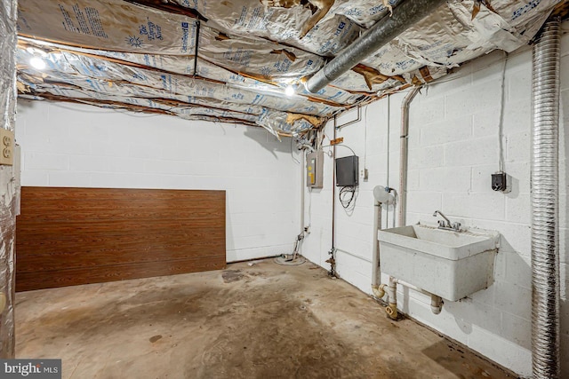 unfinished basement featuring a sink and concrete block wall