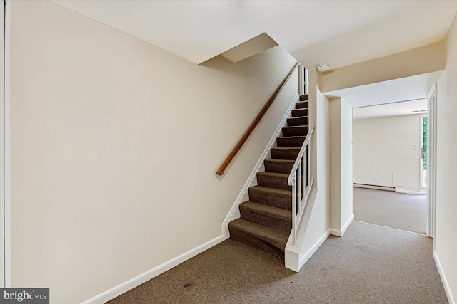 staircase featuring a baseboard heating unit, carpet floors, and baseboards