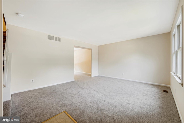 carpeted spare room featuring baseboards and a smoke detector