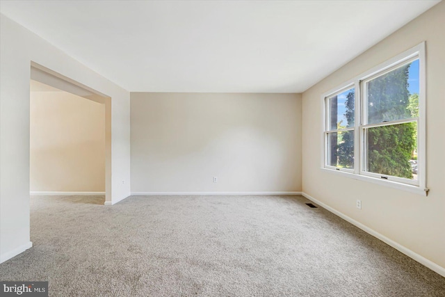 carpeted empty room with baseboards