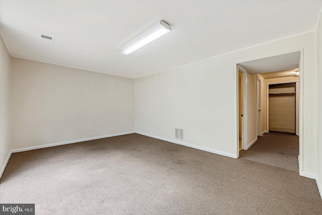 carpeted empty room featuring baseboards