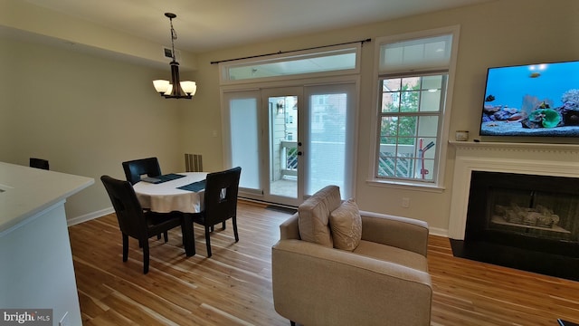 1304 Garden Wall Cir Unit 105, Reston, VA 20194 - dining area featuring light wood-type flooring, a chandelier, and baseboards