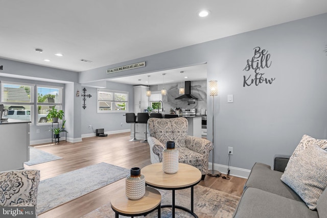 living room with light wood-style flooring, baseboards, and recessed lighting