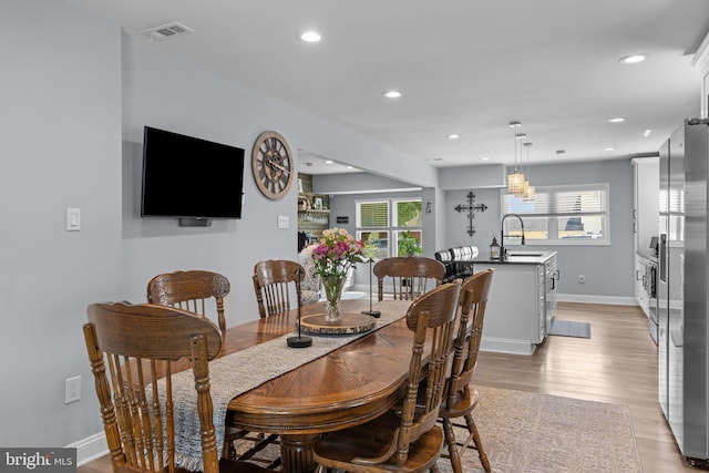 dining room featuring recessed lighting, light wood finished floors, and baseboards