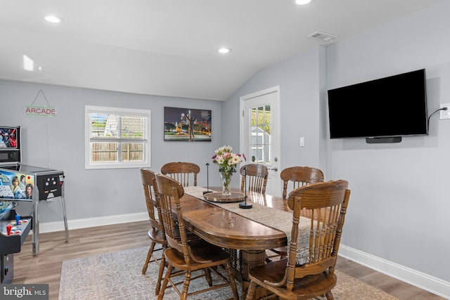 dining area featuring wood finished floors, baseboards, lofted ceiling, and recessed lighting