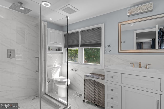 full bathroom featuring tile walls, marble look tile flooring, a marble finish shower, vanity, and toilet