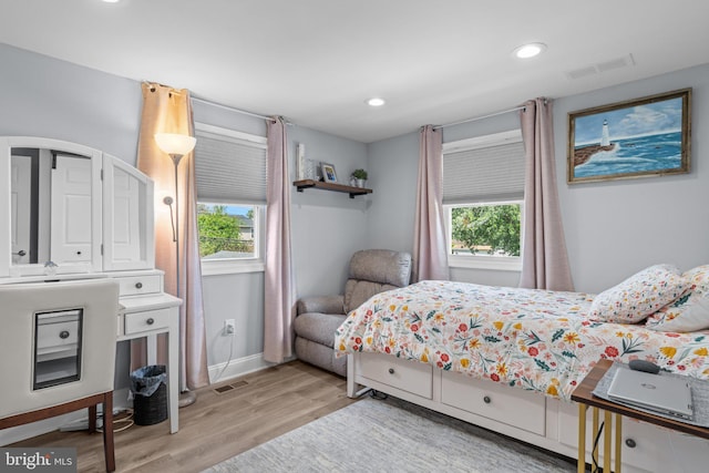 bedroom with multiple windows, light wood-type flooring, baseboards, and recessed lighting