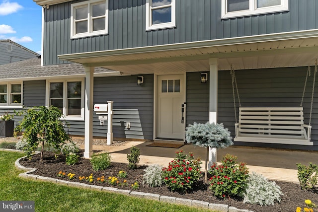 doorway to property featuring covered porch and board and batten siding
