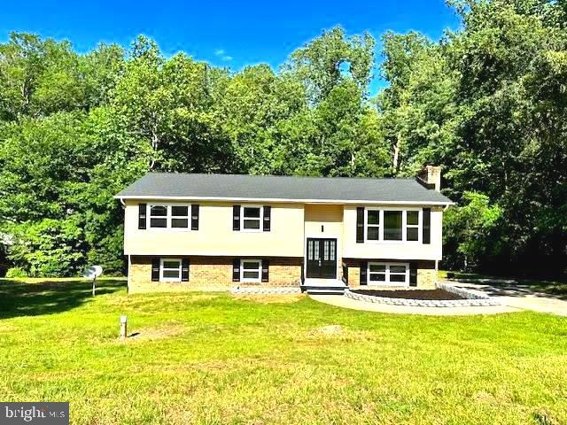 39743 Daniel Cir, Mechanicsville, MD 20659 - split foyer home featuring a chimney, a front yard, french doors, and brick siding