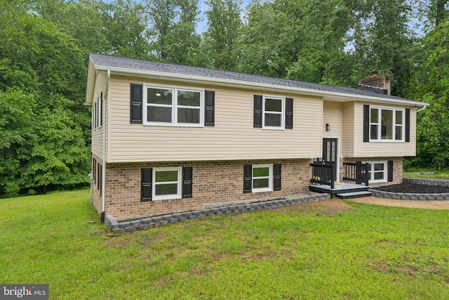 39743 Daniel Cir, Mechanicsville, MD 20659 - split foyer home featuring a front lawn, a chimney, brick siding, and view of scattered trees