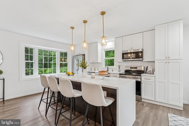 39743 Daniel Cir, Mechanicsville, MD 20659 - kitchen featuring stainless steel appliances, a center island, light wood-style flooring, and a breakfast bar area