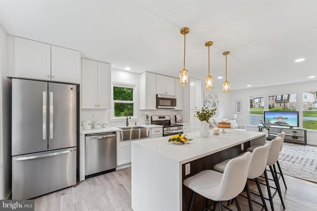 39743 Daniel Cir, Mechanicsville, MD 20659 - kitchen featuring stainless steel appliances, a sink, a kitchen breakfast bar, a center island, and light wood finished floors