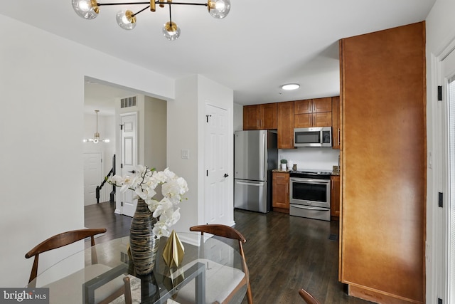 6019 Surrey Square Ln, District Heights, MD 20747 - kitchen with stainless steel appliances, a chandelier, brown cabinetry, dark wood-style floors, and baseboards