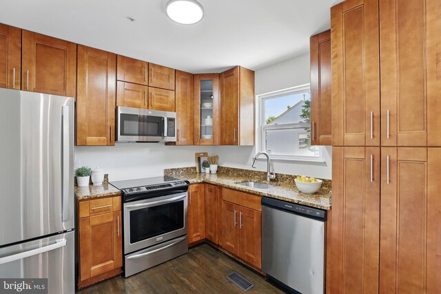 6019 Surrey Square Ln, District Heights, MD 20747 - kitchen with stainless steel appliances, dark wood-type flooring, a sink, light stone counters, and brown cabinets