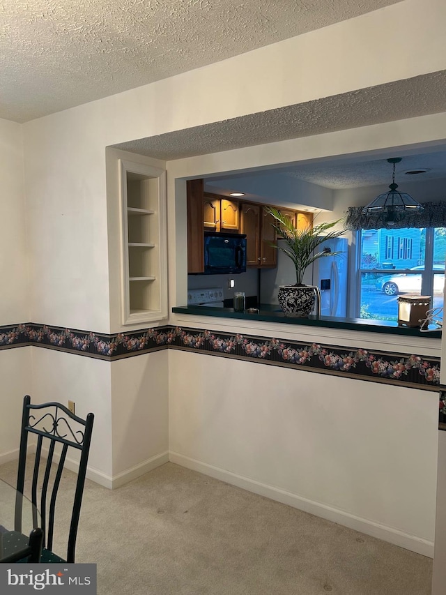 kitchen with black microwave, light carpet, a textured ceiling, dark countertops, and baseboards