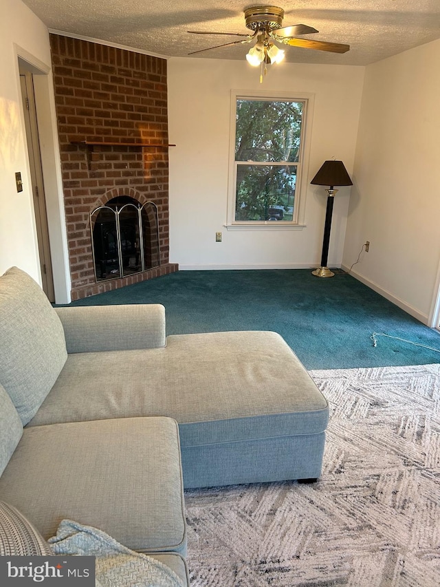 carpeted living room with ceiling fan, a textured ceiling, and a brick fireplace