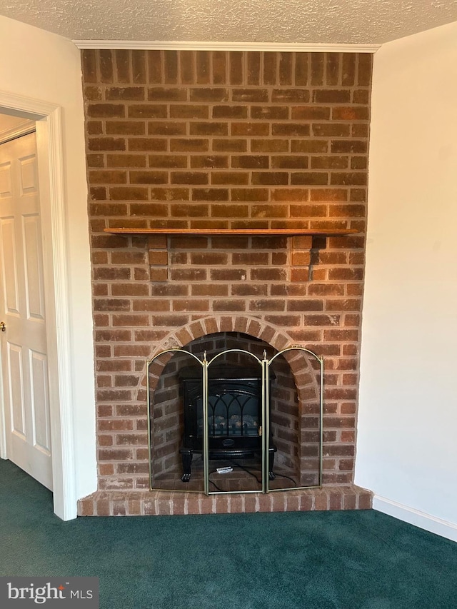 detailed view of a fireplace, carpet, and a textured ceiling