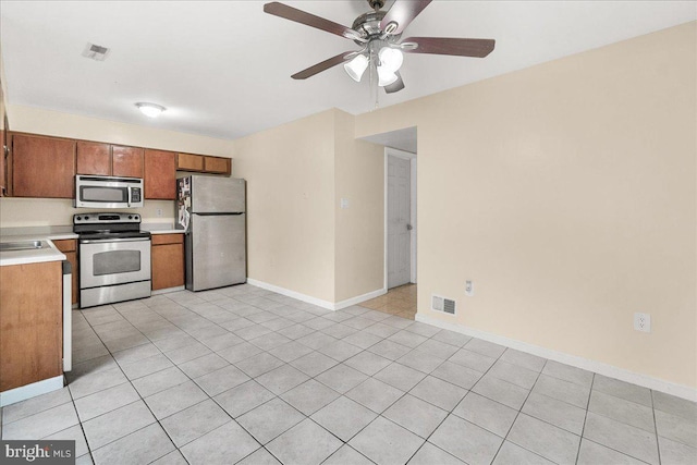 11132 Black Forest Way, Gaithersburg, MD 20879 - kitchen with stainless steel appliances, light countertops, ceiling fan, brown cabinetry, and light tile patterned floors