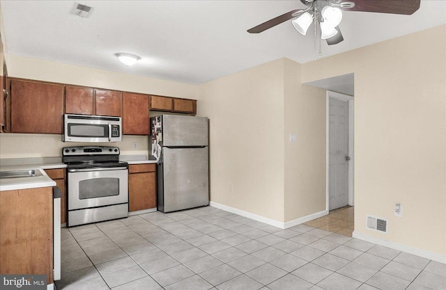 11132 Black Forest Way, Gaithersburg, MD 20879 - kitchen with stainless steel appliances, a ceiling fan, brown cabinetry, light countertops, and light tile patterned flooring