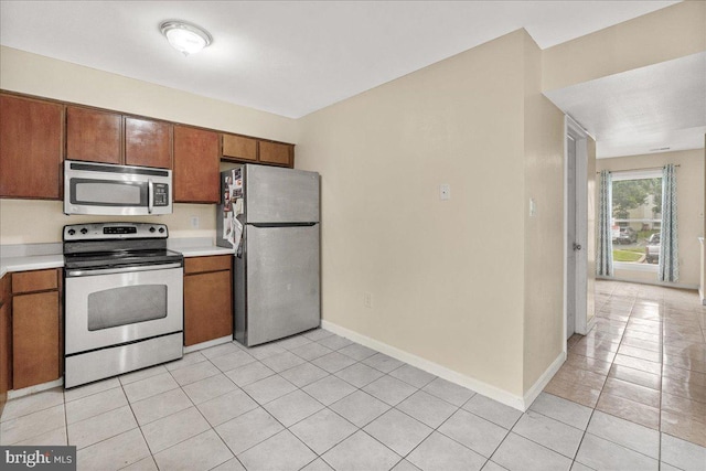 11132 Black Forest Way, Gaithersburg, MD 20879 - kitchen featuring stainless steel appliances, light countertops, light tile patterned floors, and brown cabinetry