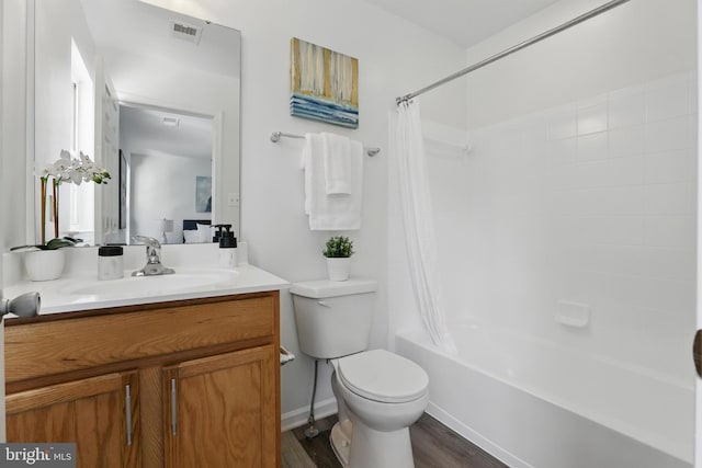 bathroom with toilet, wood finished floors, vanity, and shower / bath combo with shower curtain