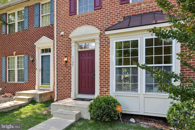 doorway to property with brick siding