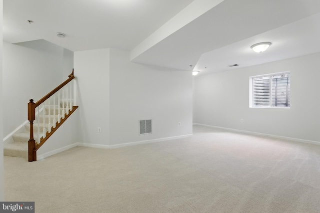 carpeted spare room featuring baseboards, stairs, and fire sprinkler in ceiling