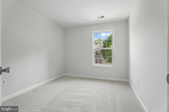 unfurnished room featuring light carpet and baseboards